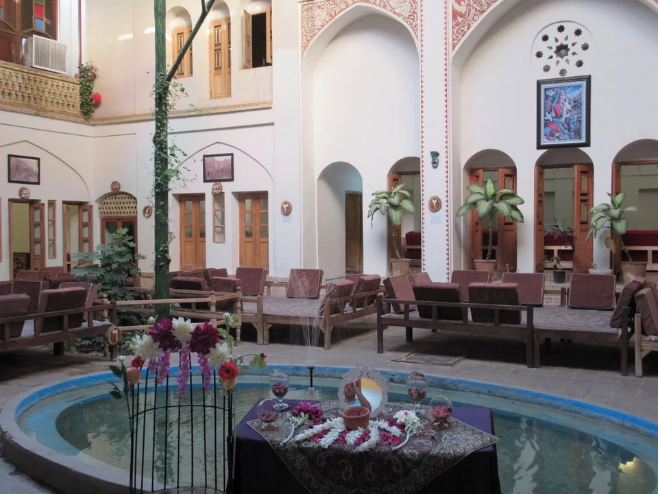 Interno elegante di un ristorante in Iran con cortile interno e fontana decorativa.