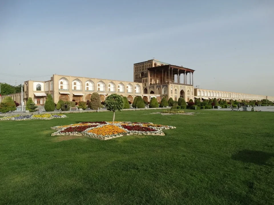 La piazza Imam a Isfahan in Iran con edifici storici e un ampio prato verde.