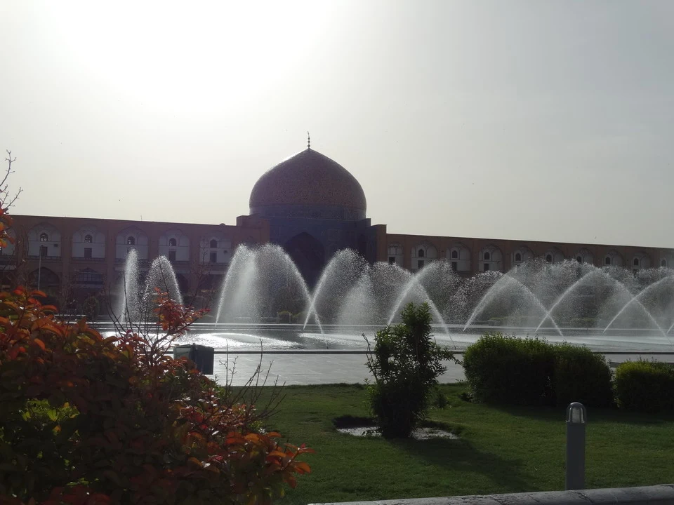 La piazza Imam è visibile con una fontana e un edificio in stile tradizionale iraniano.