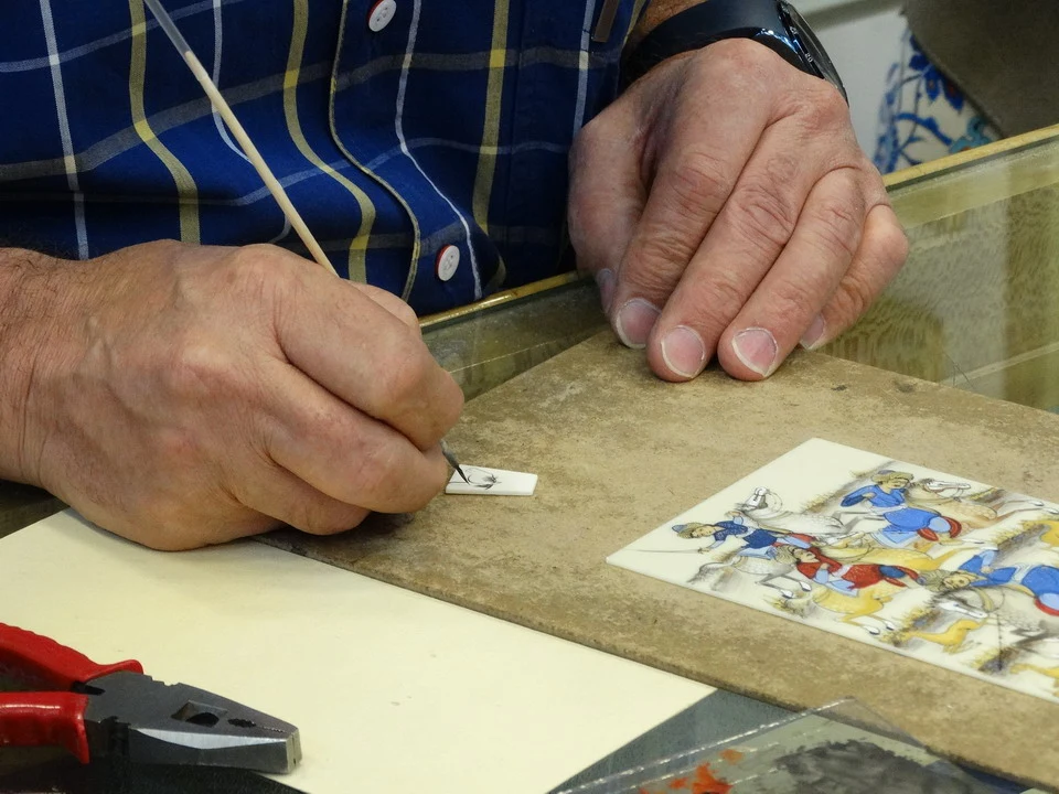 Un uomo disegna su una tavola di legno un'opera d'arte.
