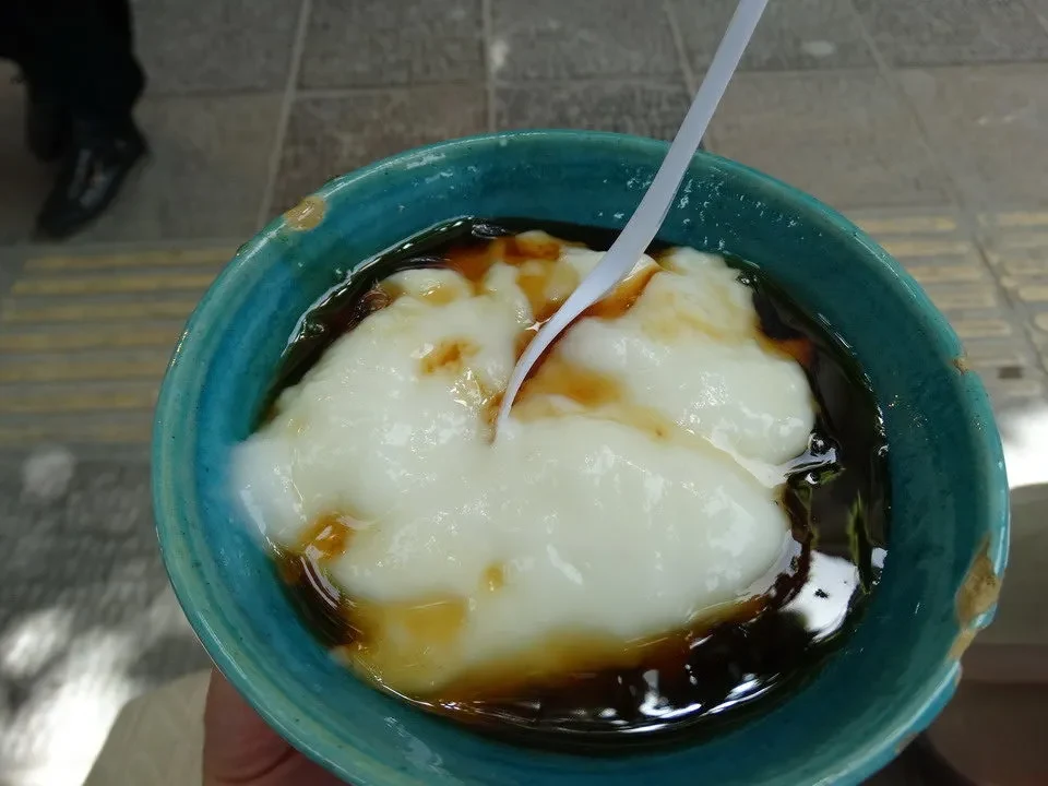 Un piatto di cibo viene mostrato in una ciotola blu con un cucchiaio immerso.