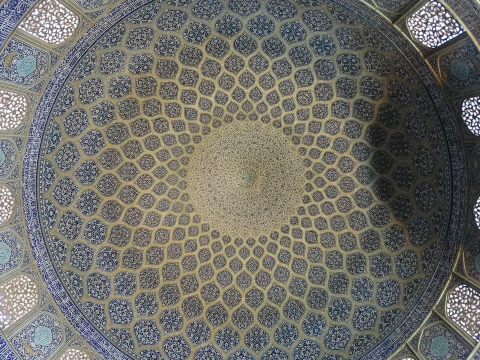 Interno decorato di un cupolone con motivi geometrici intricati.