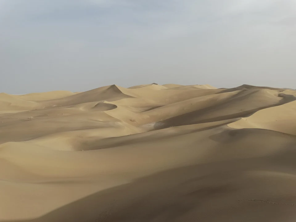 Dune sabbiosi sotto un cielo chiaro in Iran.
