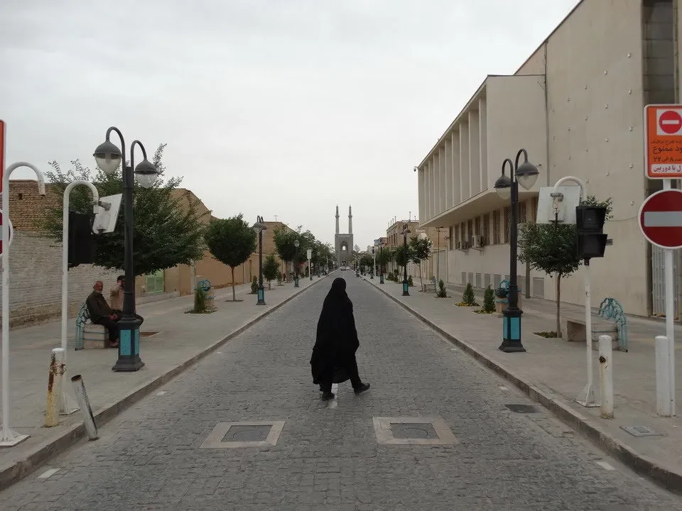 Una strada stretta e pavimentata si estende verso l'orizzonte in Iran.