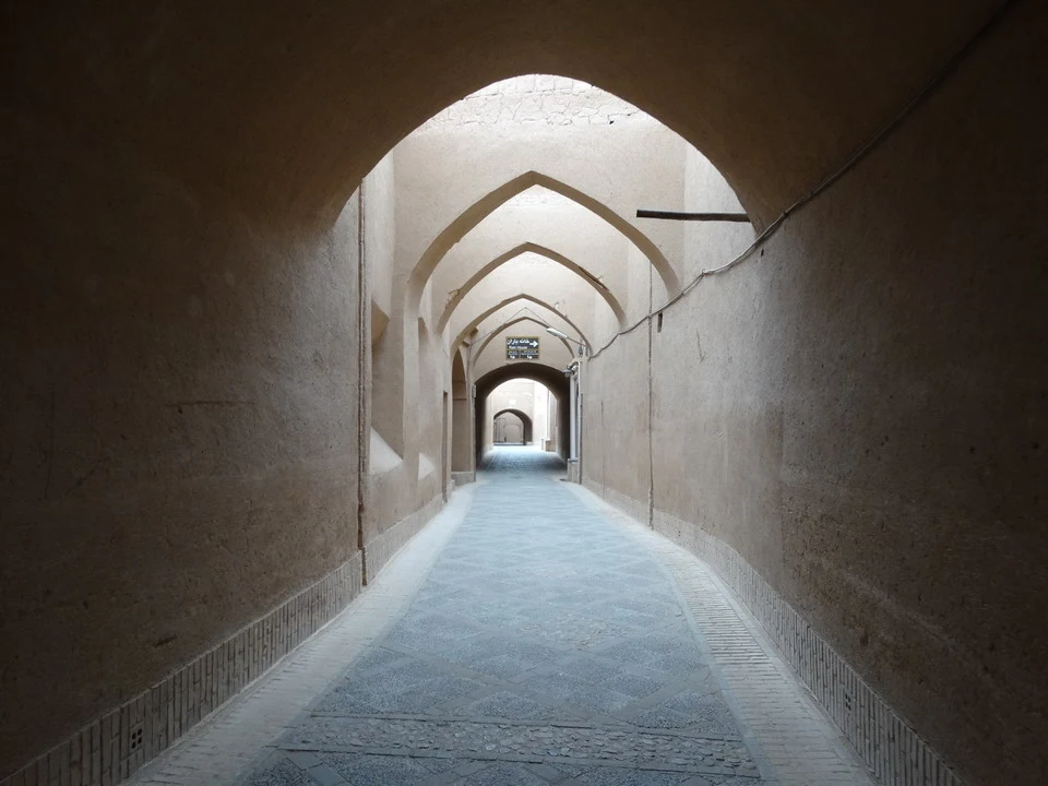 Una lunga galleria ad arco conduce attraverso un corridoio interno in pietra.