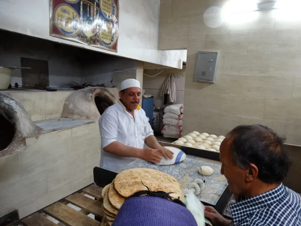 Panoramica del centro città di Yazd in Iran con panificatori al lavoro.
