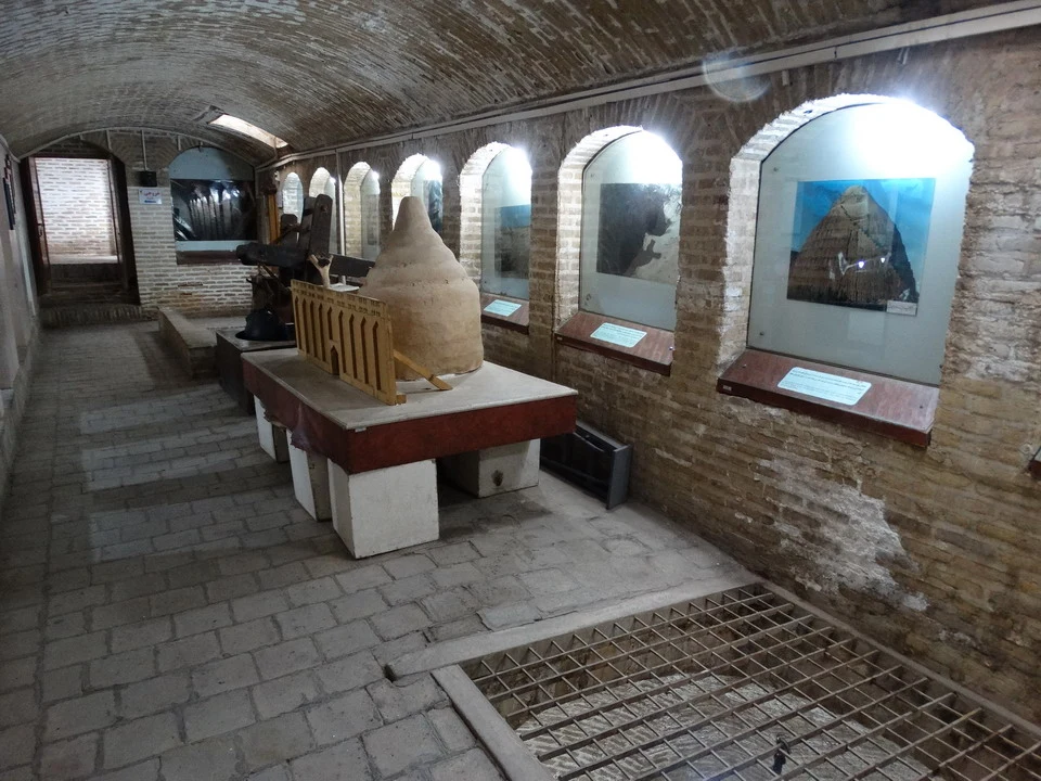 Una galleria museale con esposizioni di oggetti in un ambiente in mattoni.