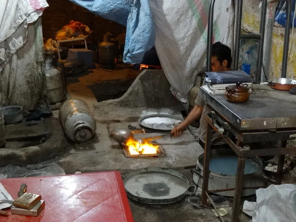 Artigiani iranesi lavorano il rame in un ambiente tradizionale.