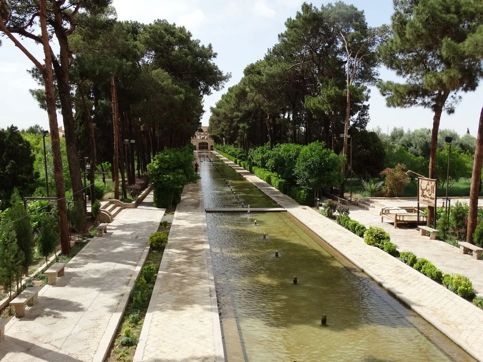 Un canale d'acqua sereno attraversa un parco alberato in Iran.