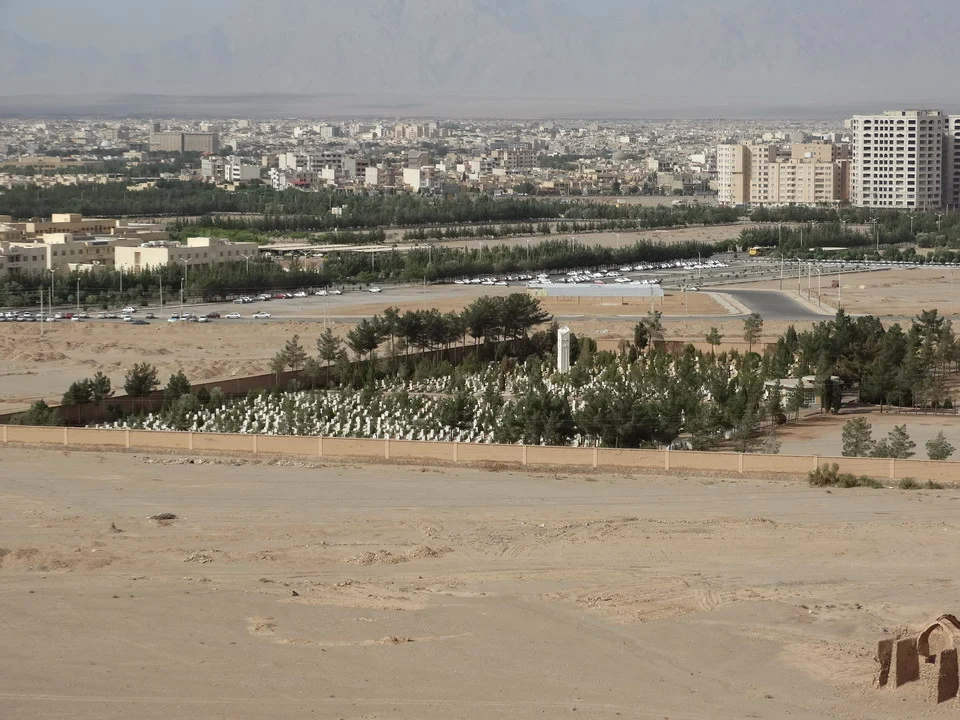 Una vista panoramica di una città iraniana con un paesaggio arido in primo piano.
