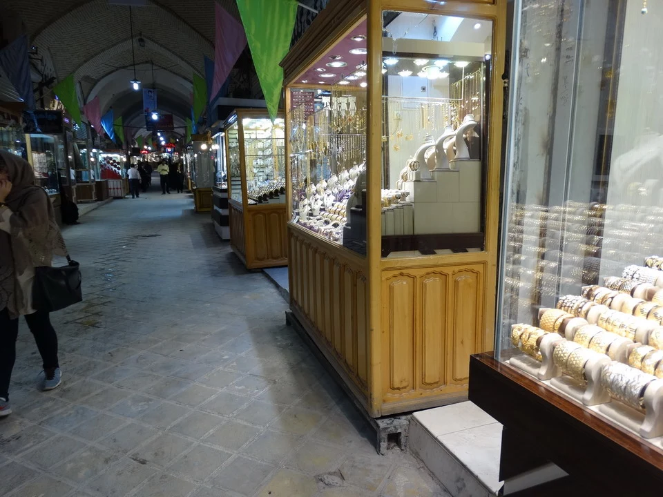 Una galleria commerciale coperta mostra bancarelle di prodotti in Iran.