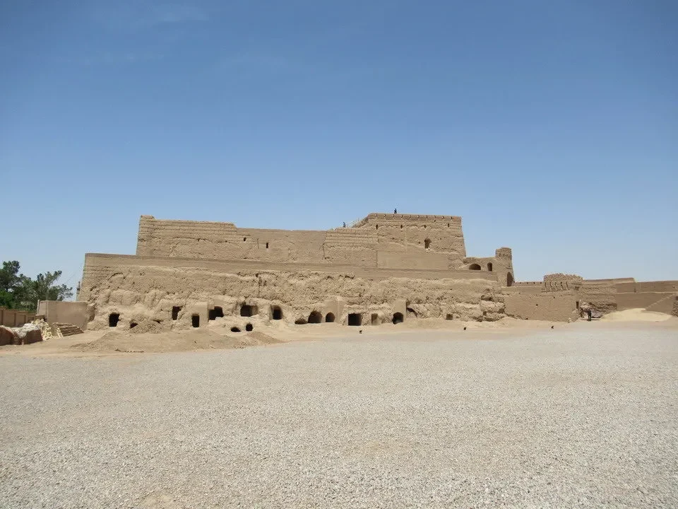 Una fortezza antica in terra di argilla si staglia sotto un cielo azzurro.