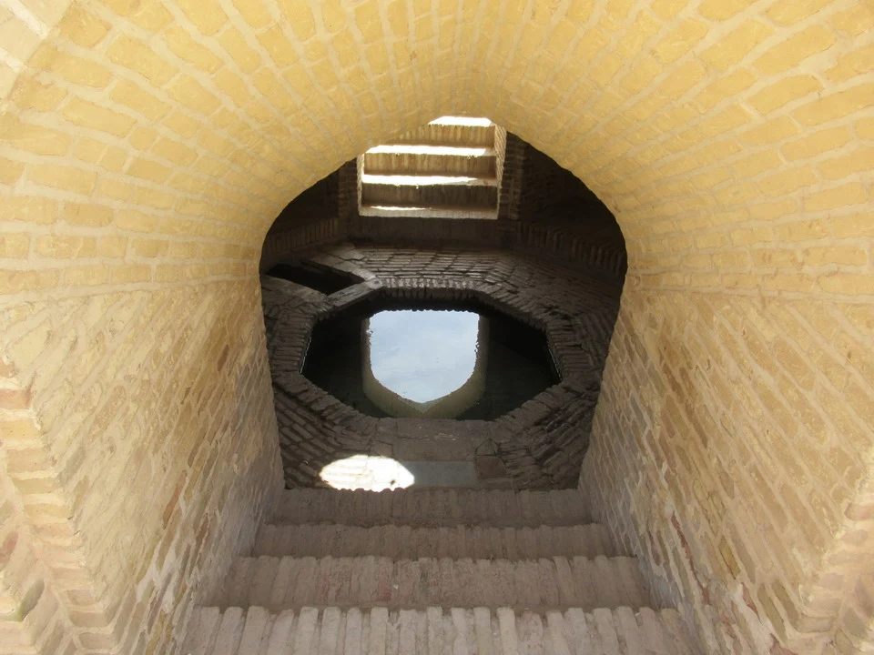Una vista interna di un caravanserraglio in mattoni con una struttura a volta.