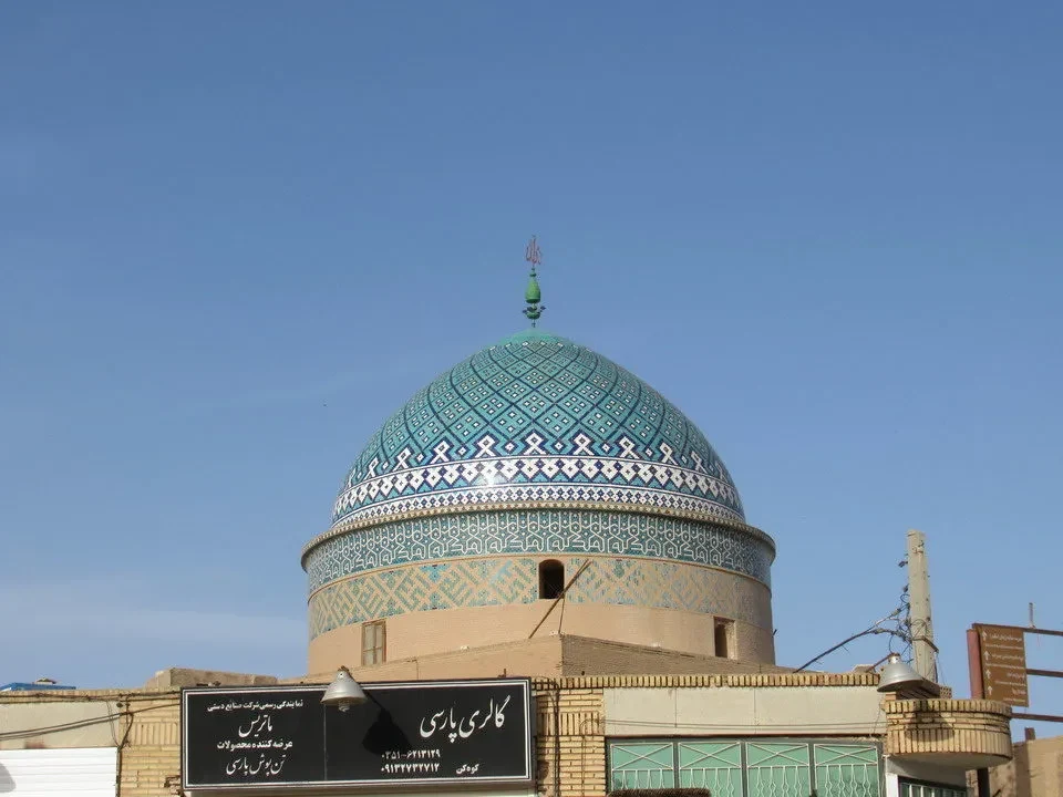 Cupola decorata di un edificio iraniano con motivi geometrici blu e verdi.
