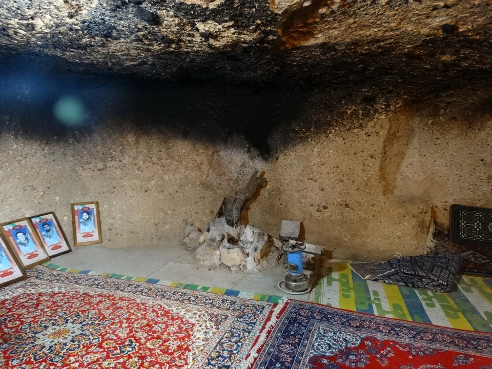 Interno rustico di una grotta o struttura rocciosa con pavimenti tappezzati.