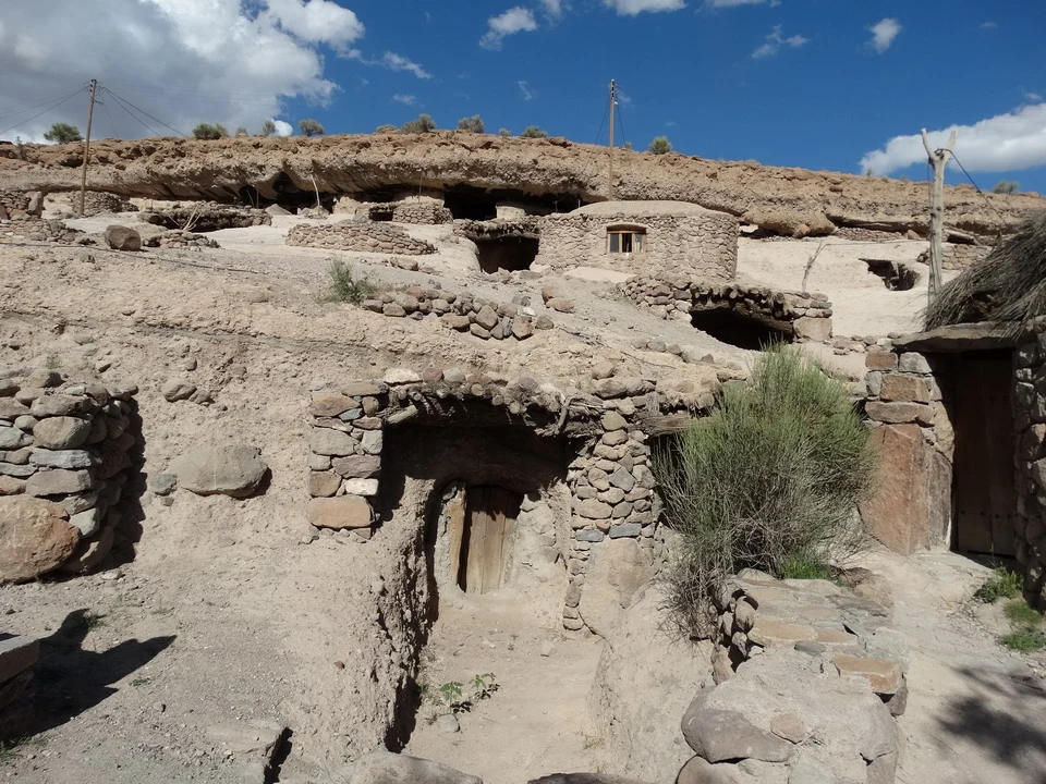 Un villaggio troglodita in pietra si estende su un paesaggio arido dell'Iran.