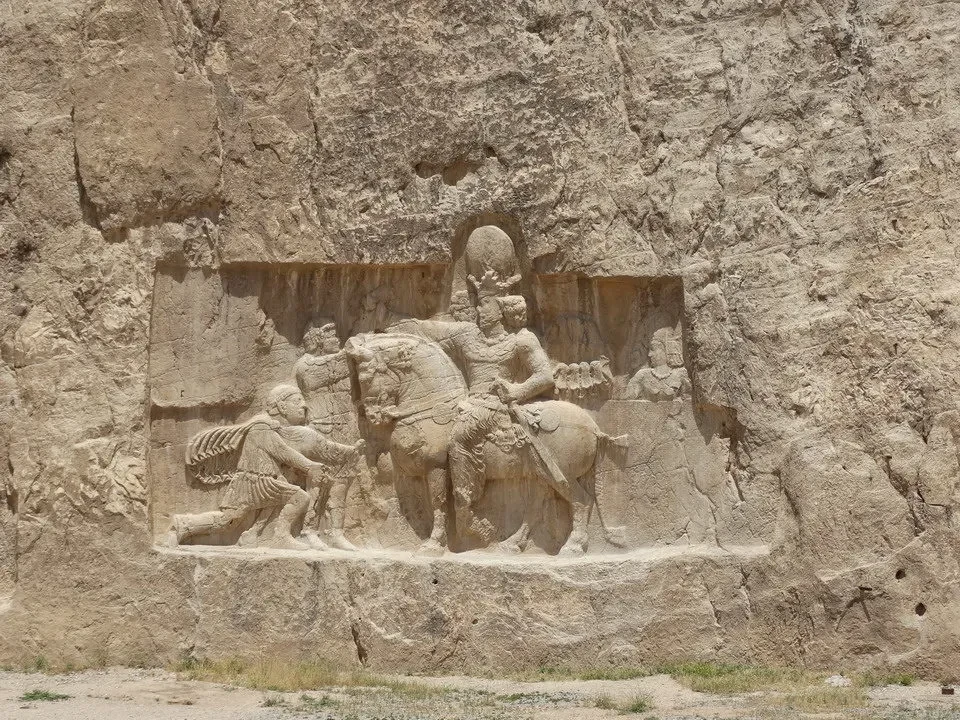 Rilievo rupestre raffigurante scene di vita antica in pietra.