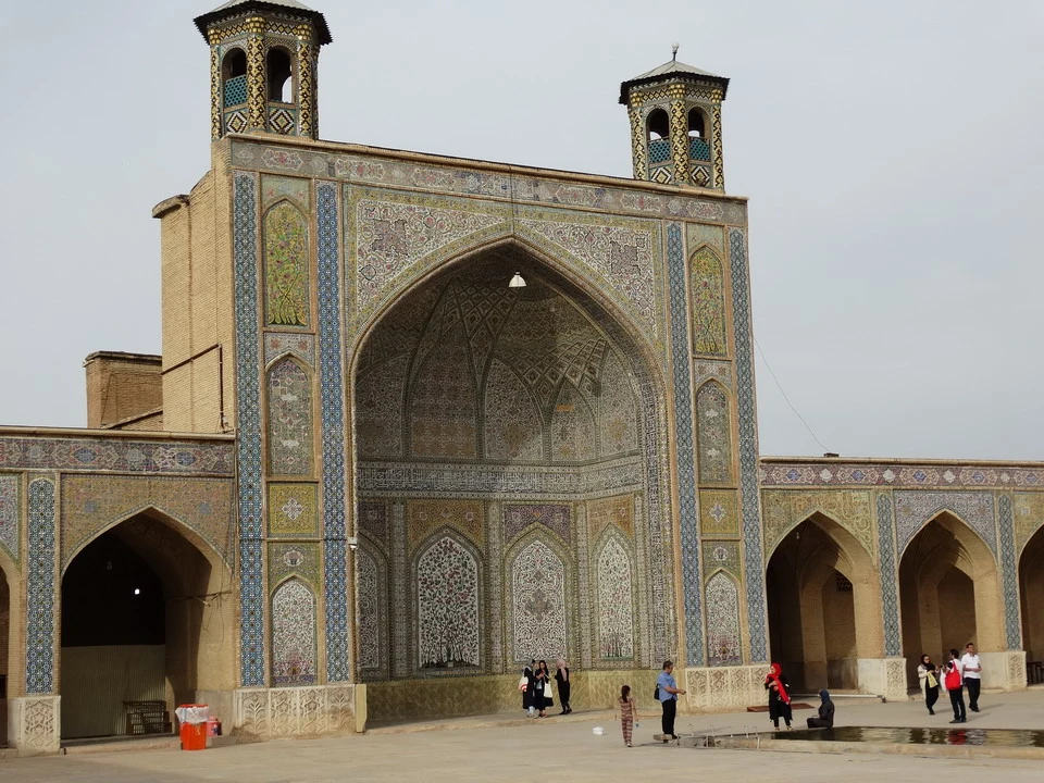 Portale decorato in stile islamico con archi e torrette in mattoni e piastrelle.