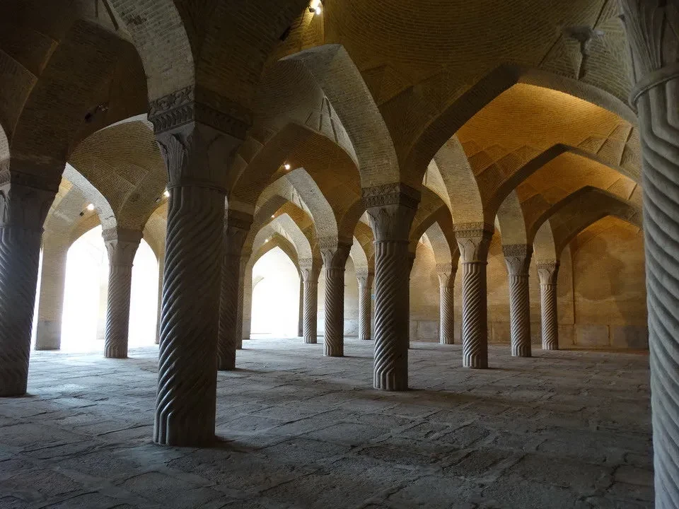 Interno di un corridoio con archi e colonne in pietra.