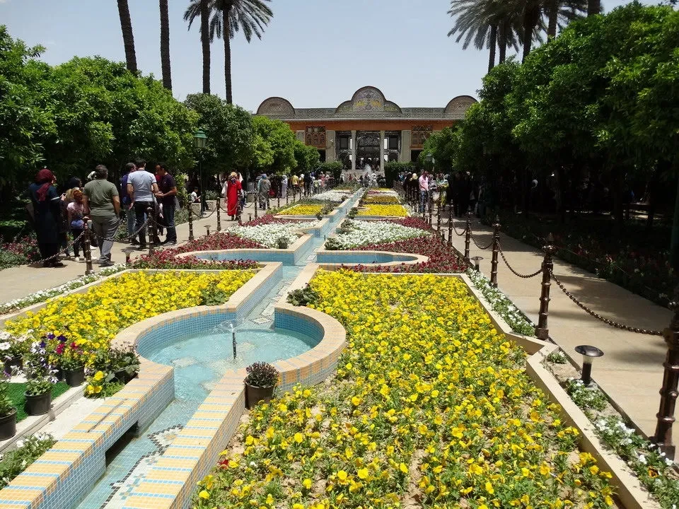 Giardino formale iraniano con fontane e sentieri decorati.