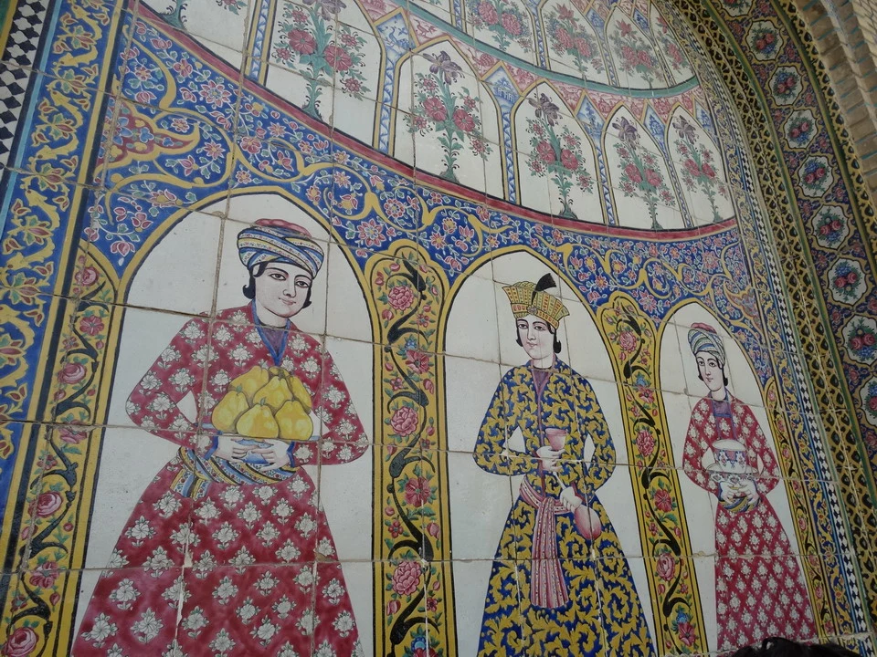 Mosaico murale decorato con figure femminili in abiti tradizionali iraniani.