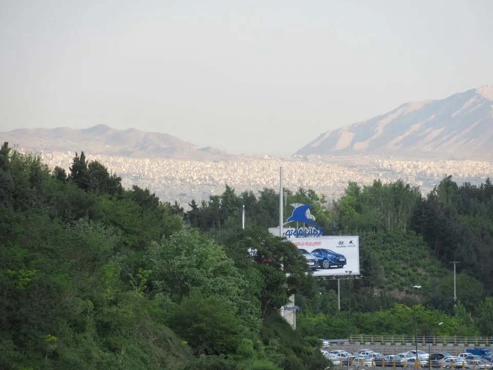 Vista panoramica della città di Teheran con montagne sullo sfondo.