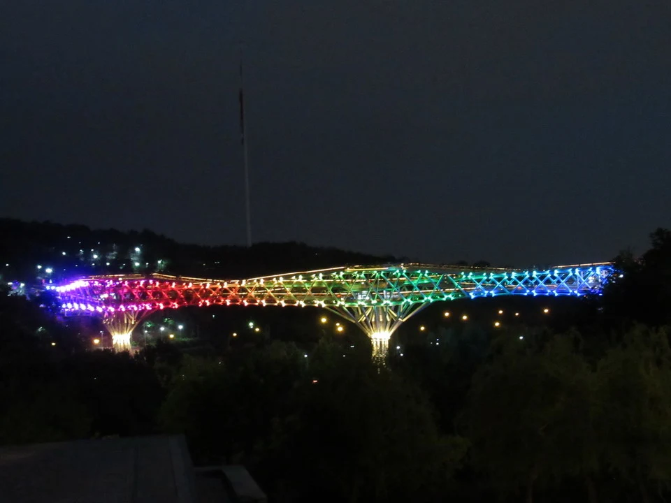 Il ponte di Teheran-Tabiat illuminato di notte mostra una struttura a traliccio colorata.