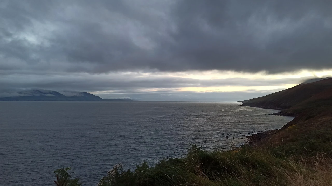 Paesaggio marino e costiero in Irlanda sotto un cielo nuvoloso.