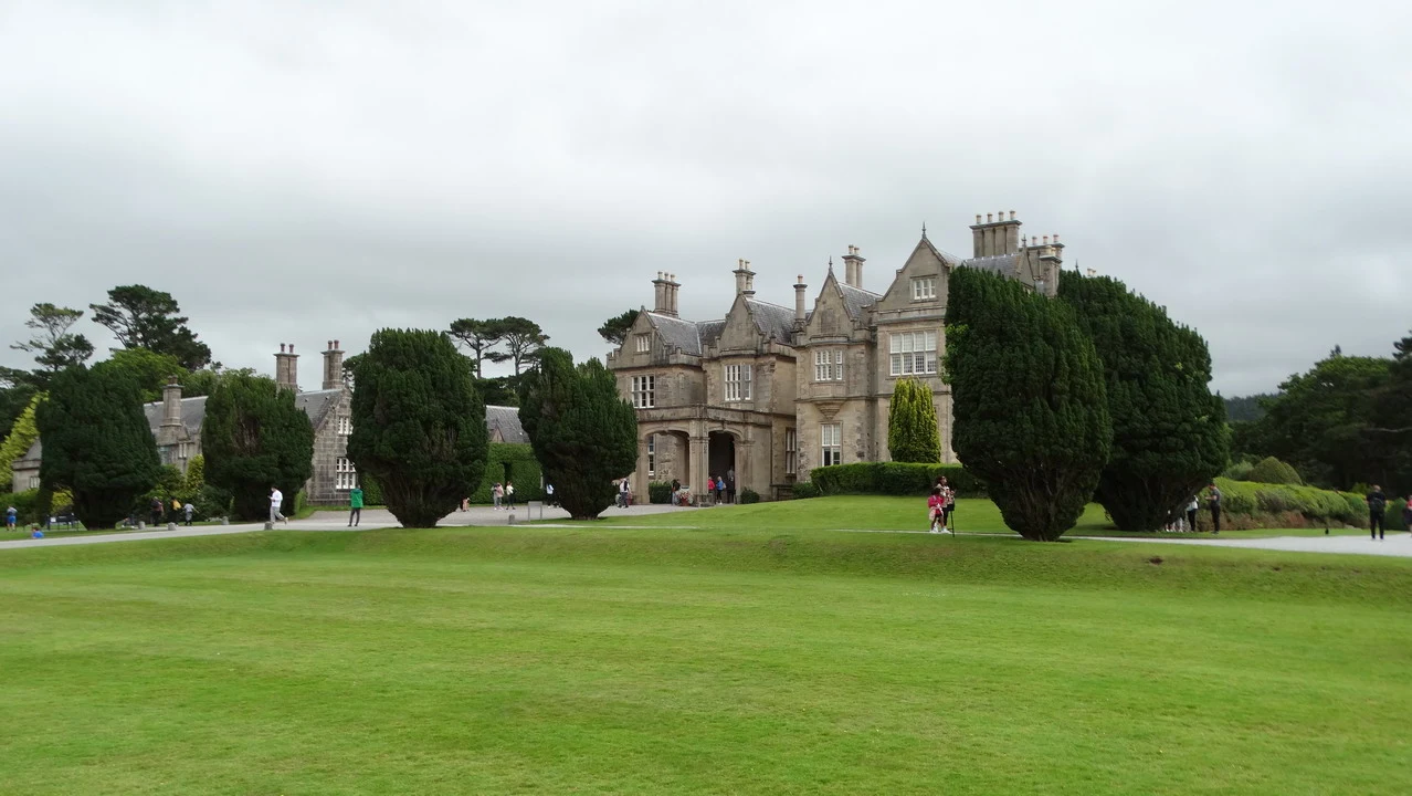Una veduta esterna di una grande casa in Irlanda con ampi giardini verdi.
