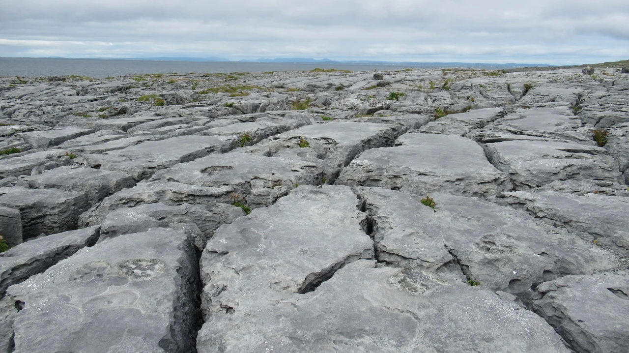 Paesaggio roccioso e accidentato della Burren in Irlanda sotto un cielo nuvoloso.