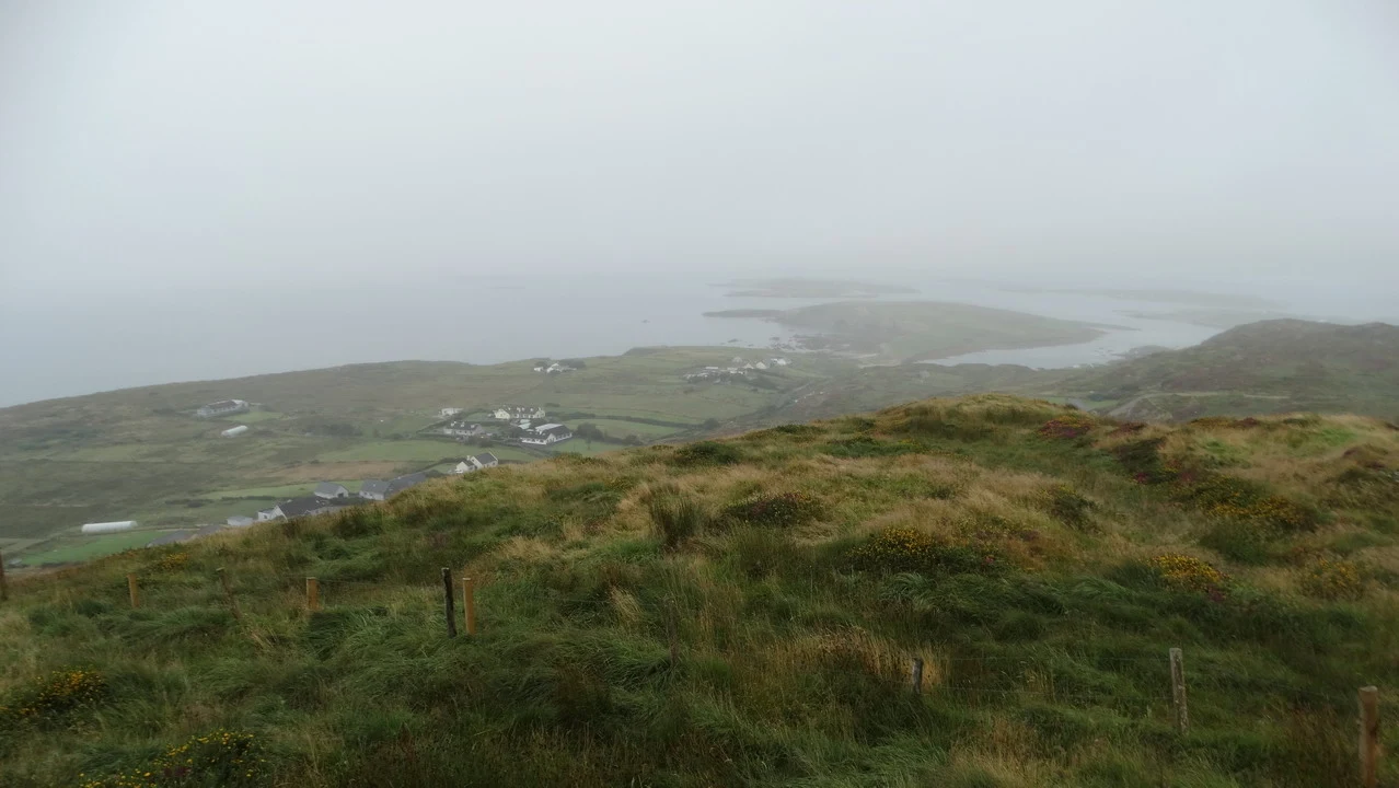 Paesaggio marino e collinare coperto di nebbia in Irlanda.
