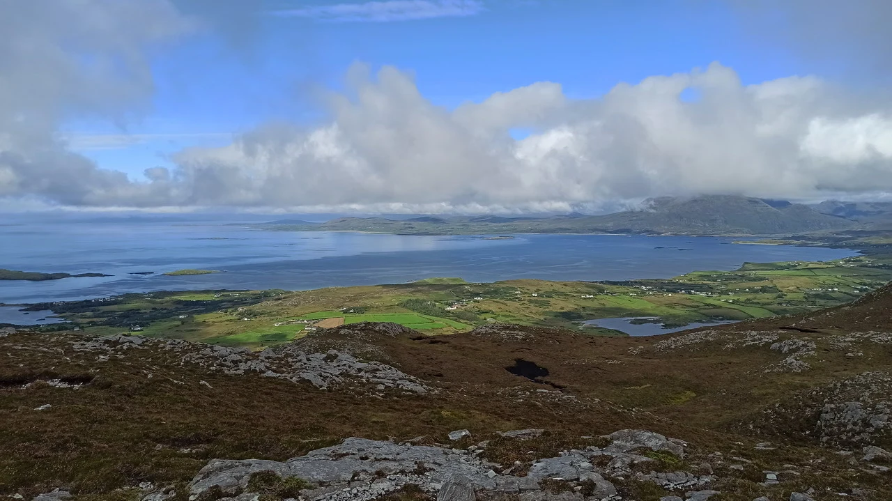 Panorama montano e costiero irlandese con nuvole basse.