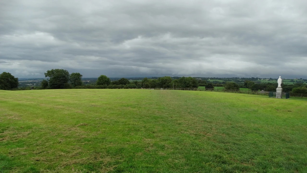 Vasto paesaggio verde e aperto in Irlanda sotto un cielo nuvoloso.