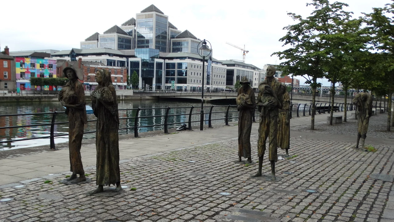 Statue di fronte a un edificio moderno lungo il fiume in Irlanda.