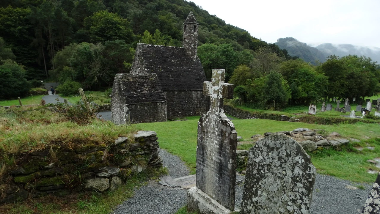 Una chiesa in pietra si trova in un paesaggio verde e collinare in Irlanda.