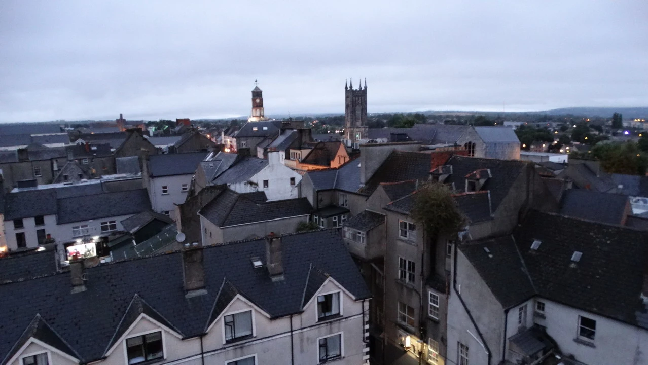 Vista panoramica dei tetti storici di una città irlandese al crepuscolo.