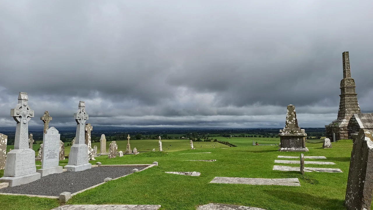 Vista panoramica del Rock of Cashel e del cimitero in Irlanda sotto un cielo nuvoloso.