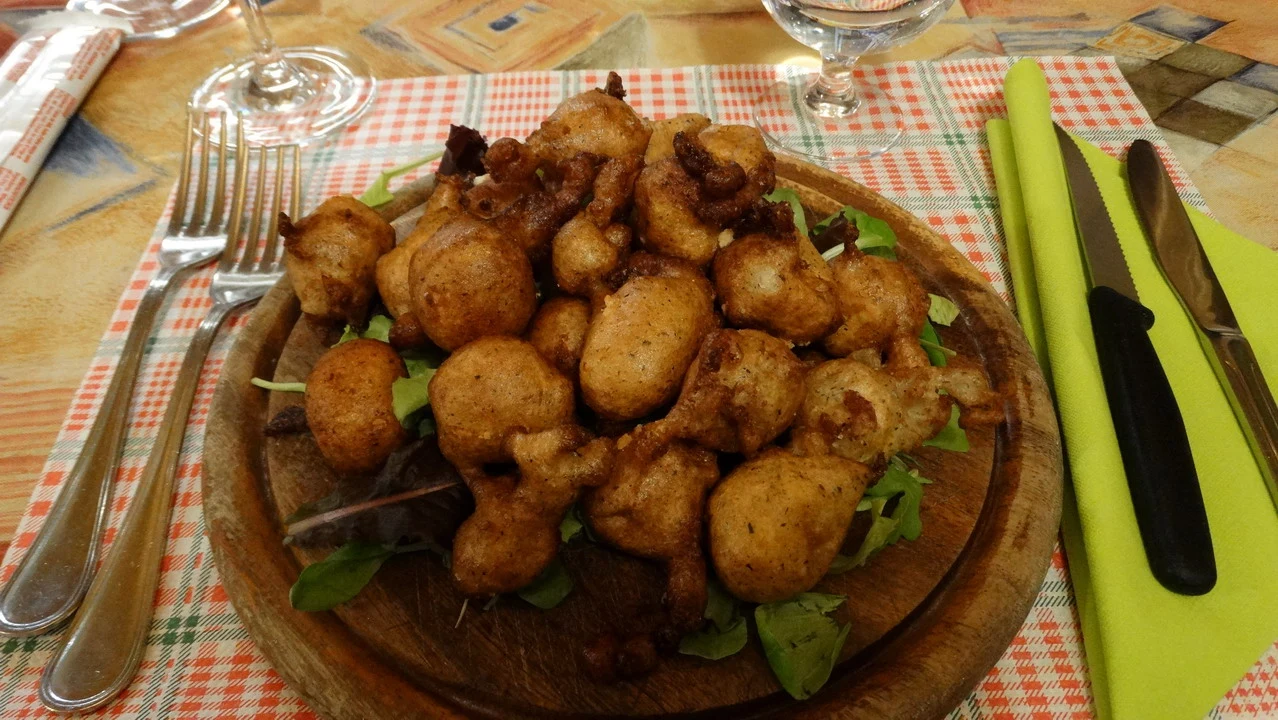 Un piatto di cibo viene servito su un tagliere di legno con posate.