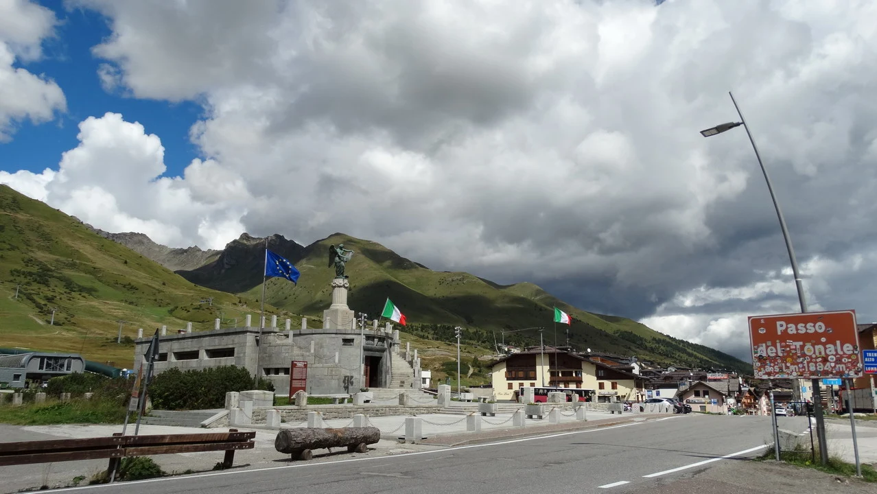 Cavalieri attraversano una strada panoramica nelle Alpi italiane.