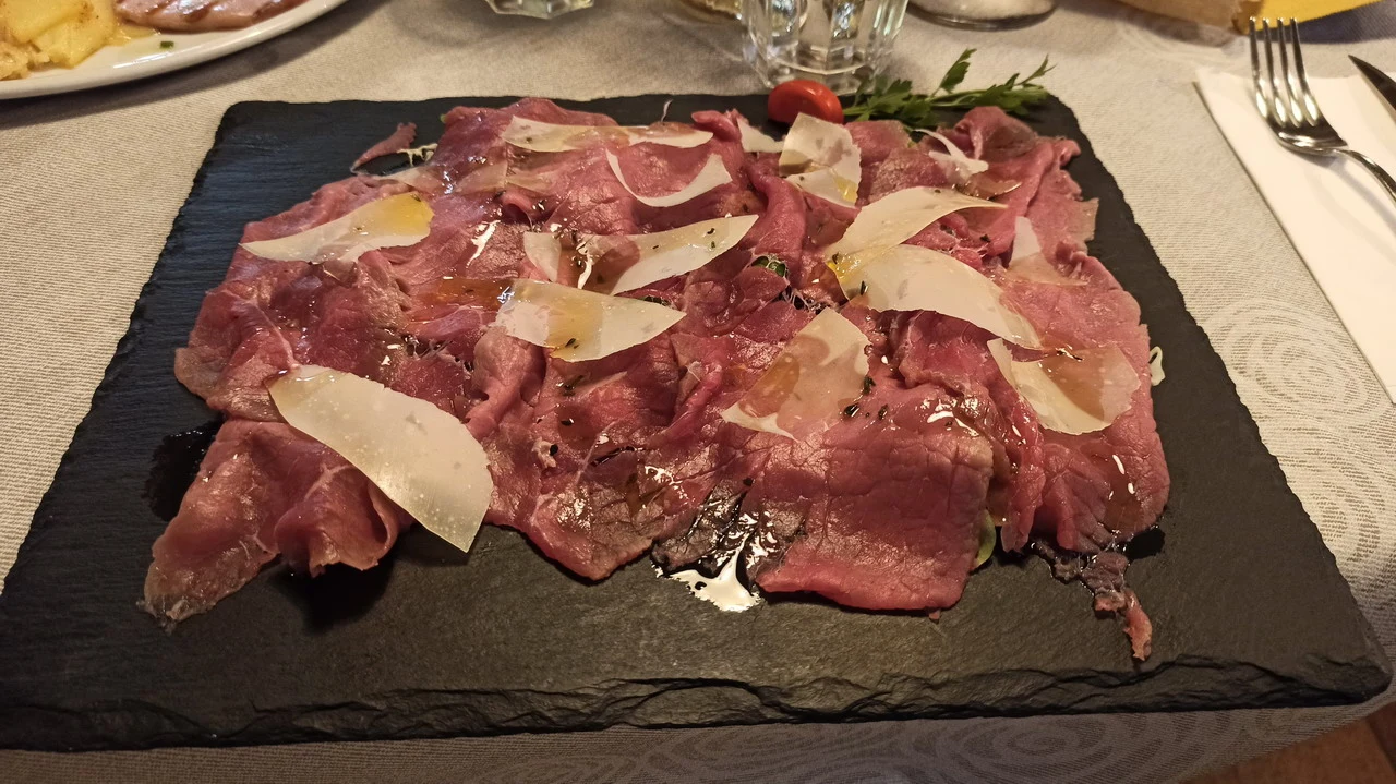 Carne cruda servita su un tagliere con formaggio.