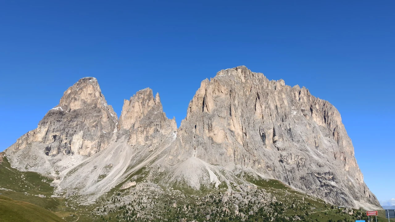 Cavalieri cavalcano le Alpi italiane con uno sfondo montuoso imponente.