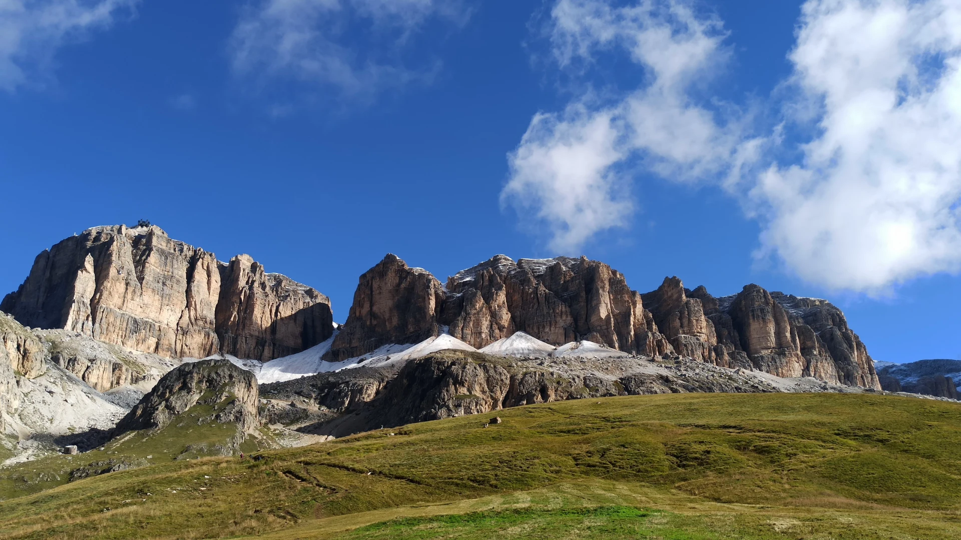 Cavalieri cavalcano attraverso le Alpi italiane con paesaggi montani imponenti.