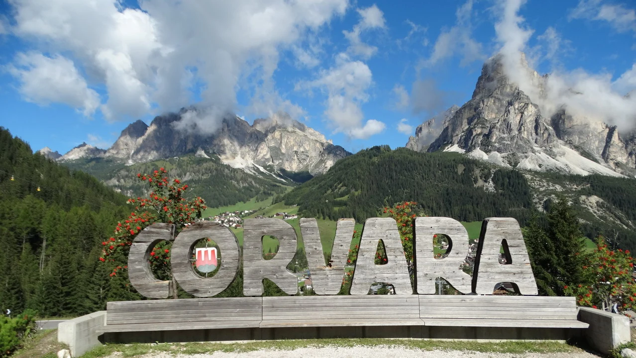 Cavalieri attraversano le Alpi italiane con uno sfondo montano imponente.