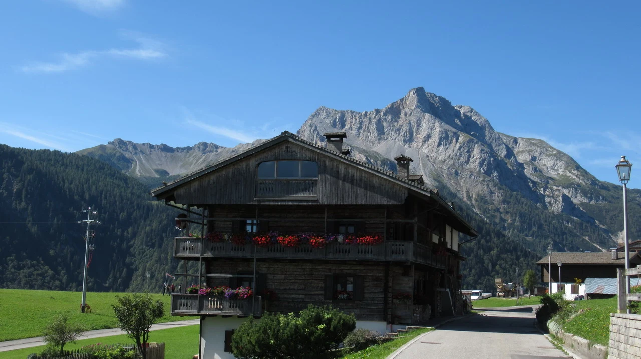 Cavalieri attraversano un paesaggio montano nelle Alpi italiane.