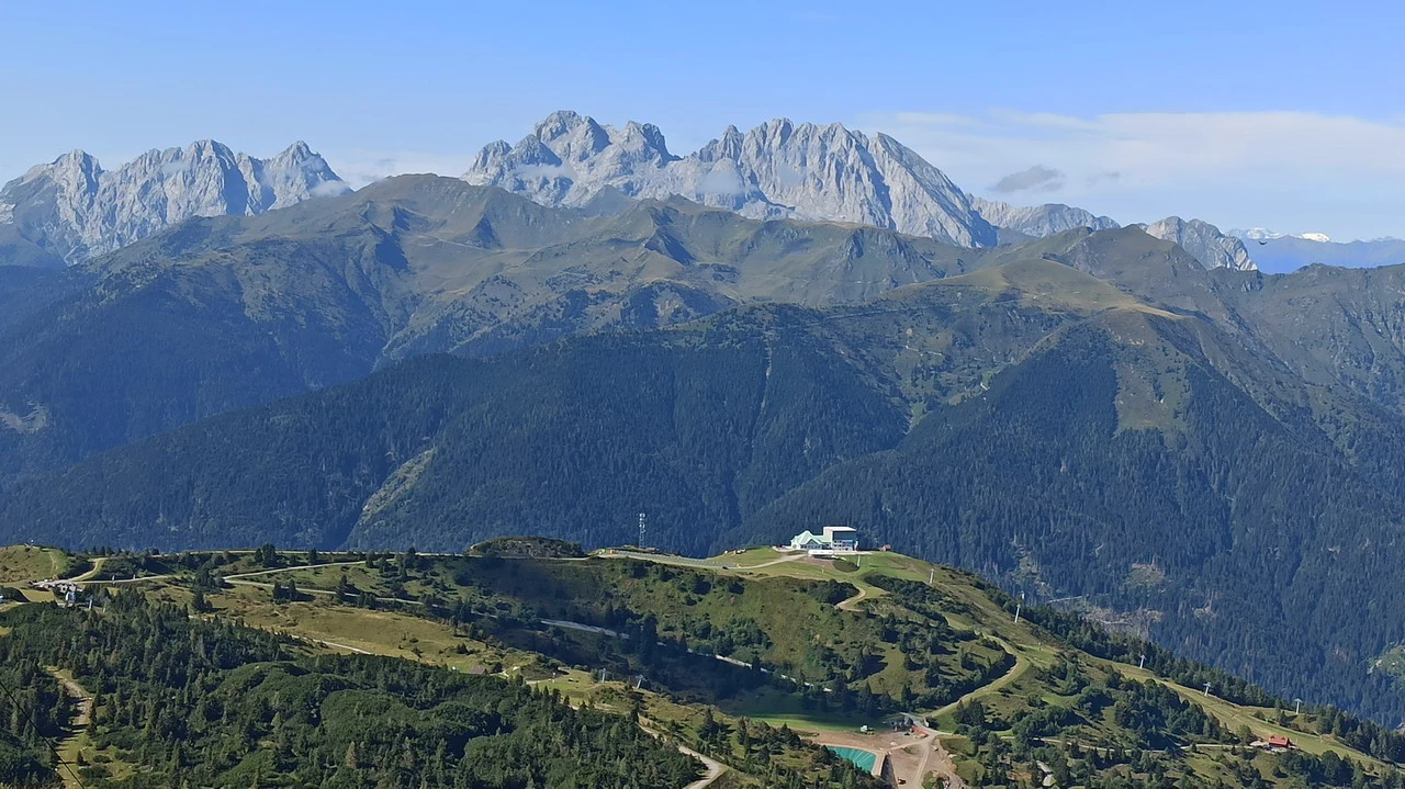 Cavalieri attraversano le Alpi italiane in una vasta valle montuosa.