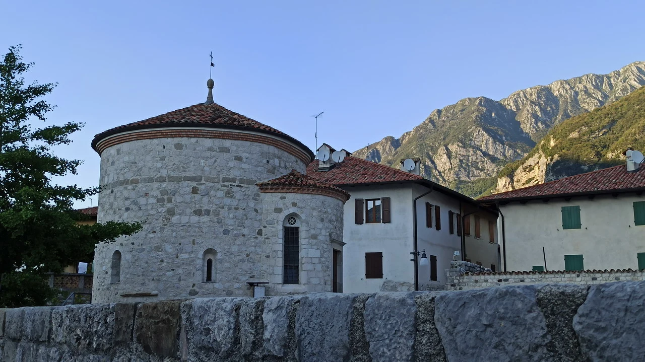 Vista panoramica di un edificio storico arroccato su una scogliera alpina.