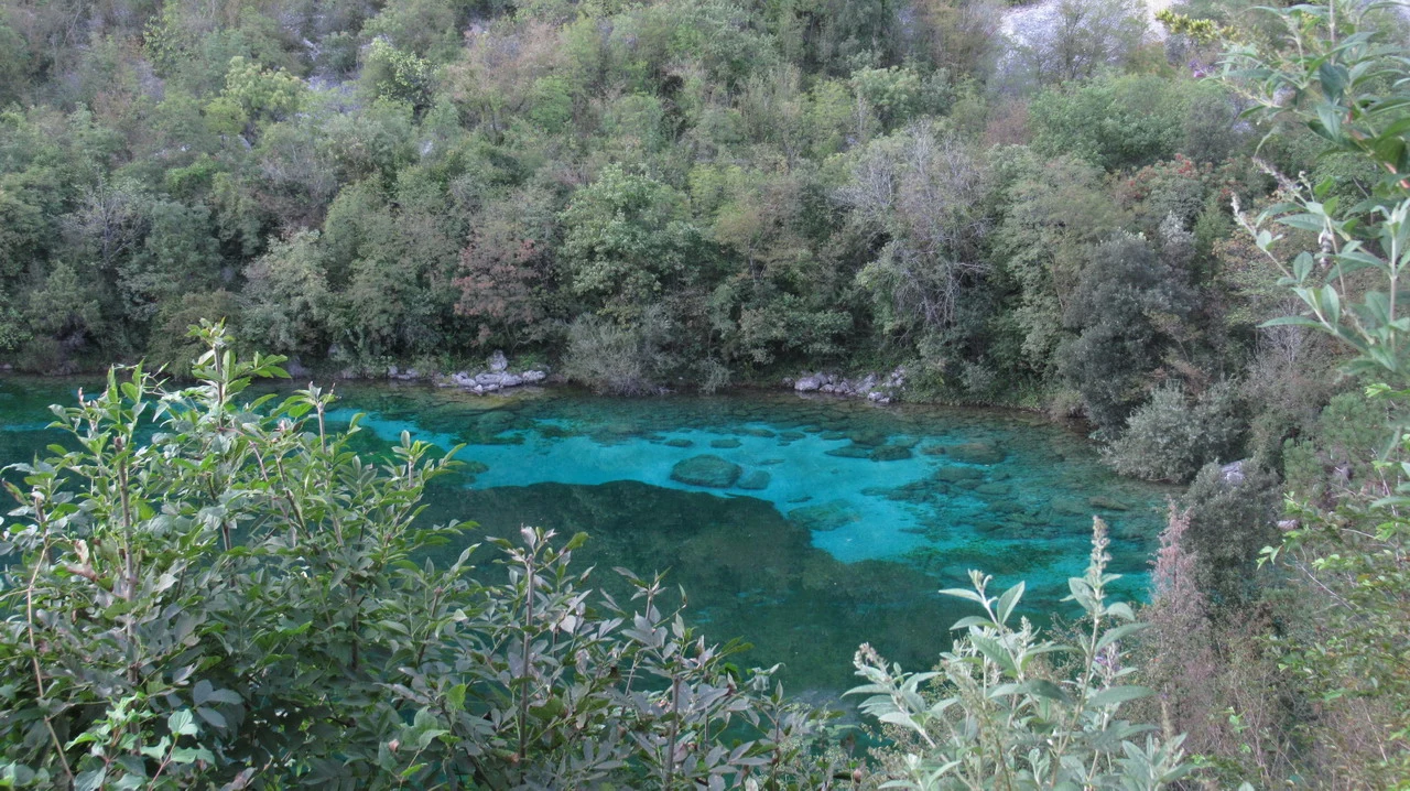 Cavalieri attraversano un fiume cristallino nelle Alpi italiane.