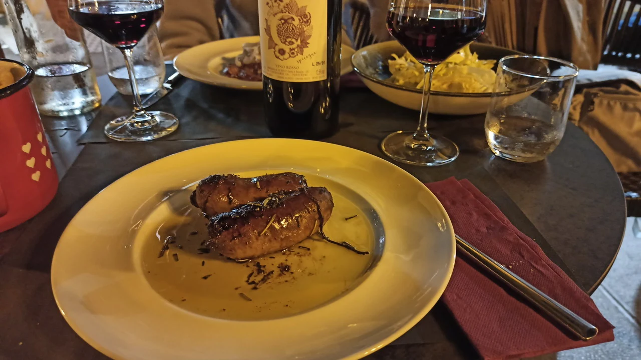 Un tavolo apparecchia una cena con carne e vino nelle Alpi italiane.