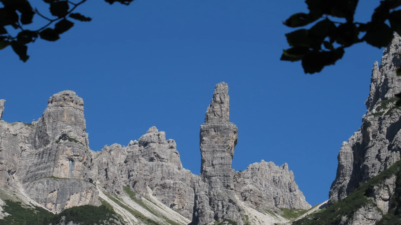 Cavalieri attraversano le Alpi italiane con uno sfondo di montagne rocciose.
