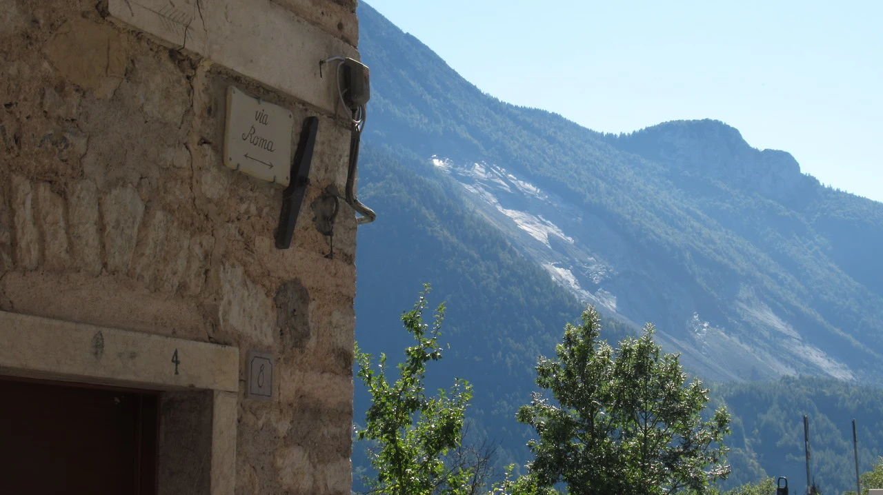 Cavalieri attraversano un paesaggio montano nelle Alpi italiane.